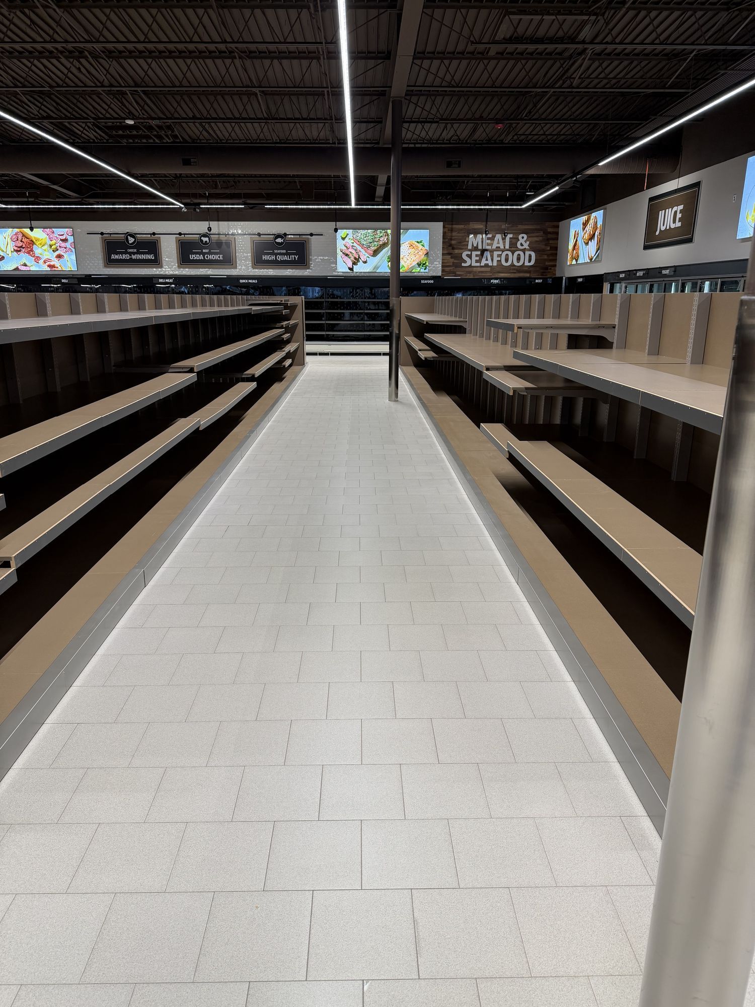 Grocery aisle of empty shelving under new light fixtures