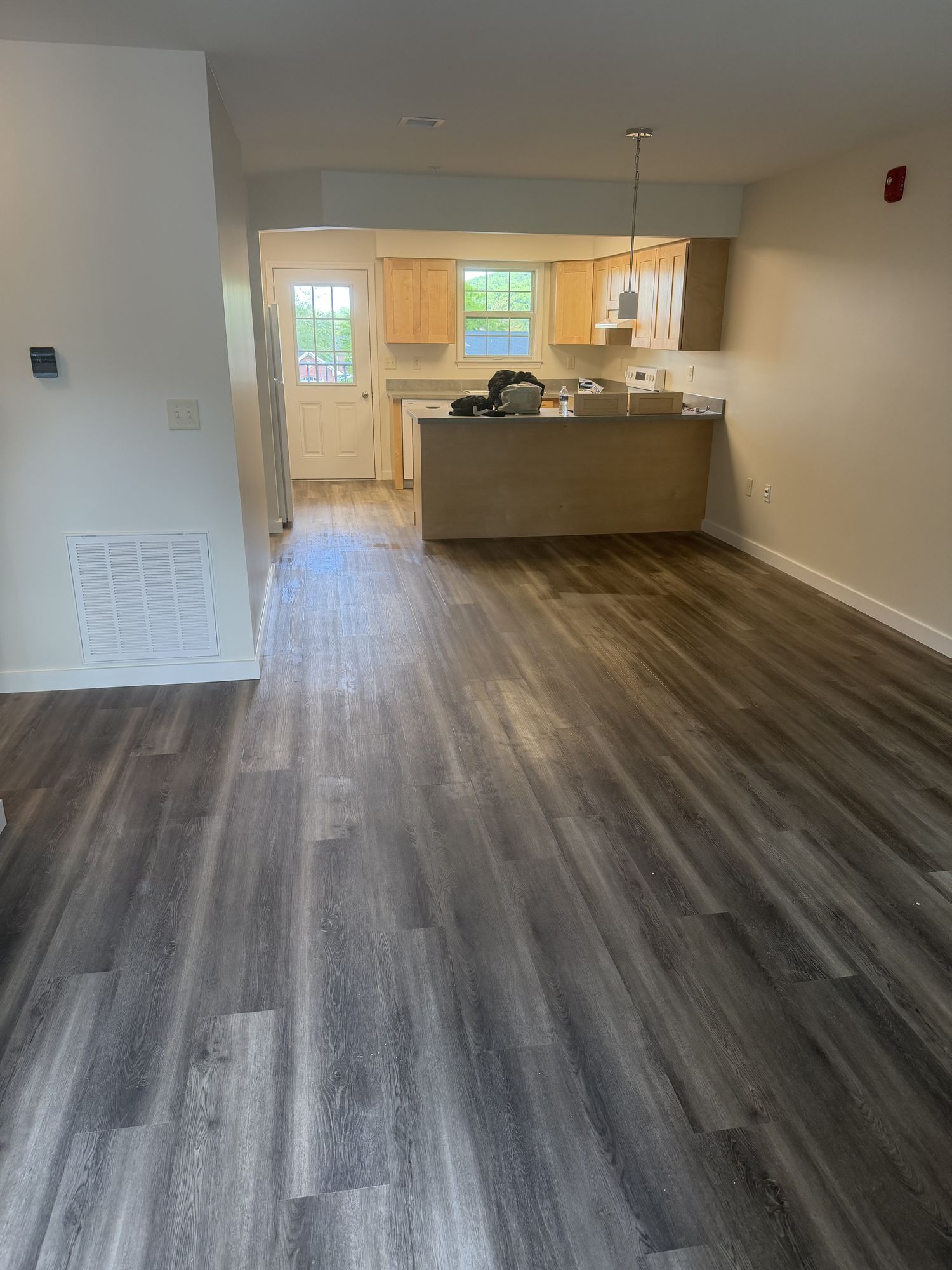 Apartment unit with plank flooring and kitchen at the far end